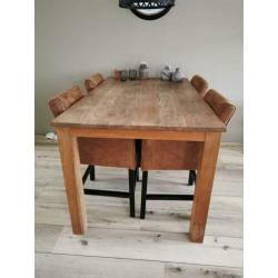 Robuuste teakhouten tafel met nette suède leren stoelen