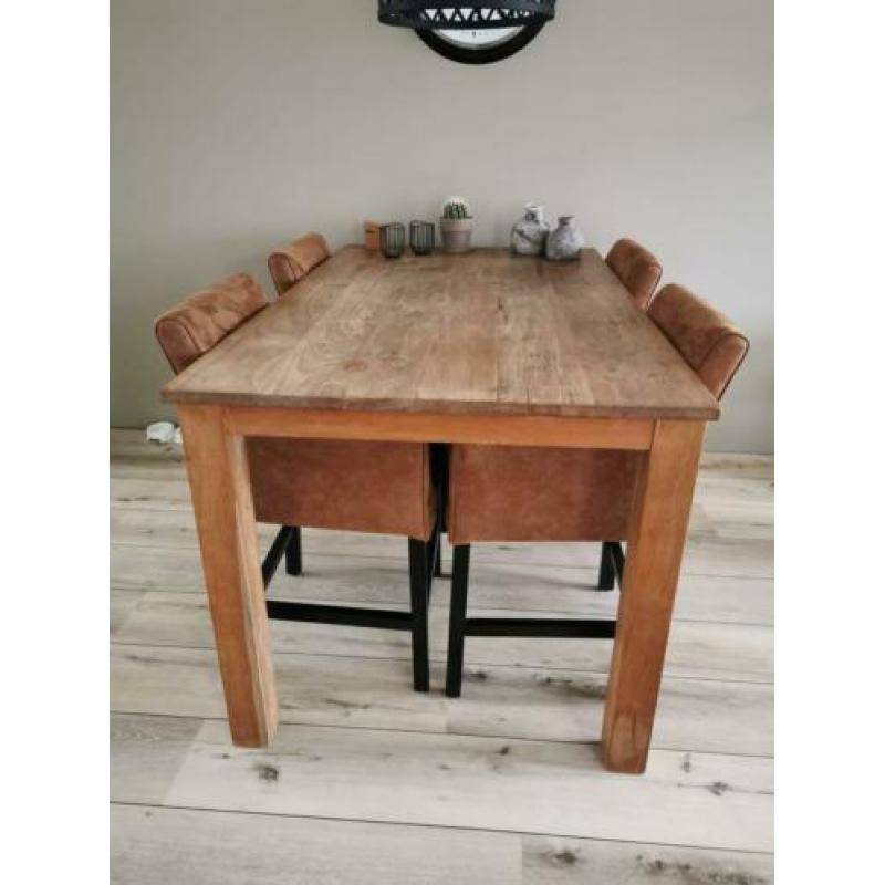 Robuuste teakhouten tafel met nette suède leren stoelen