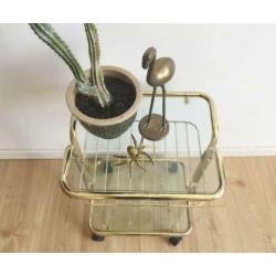 Goudkleurige vintage bijzet tafel op wielen. Retro trolley